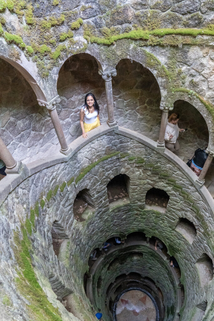 Shivani standing inside the initiation well at Quinta da Regaleira, surrounded by enchanting architecture and intricate symbolism