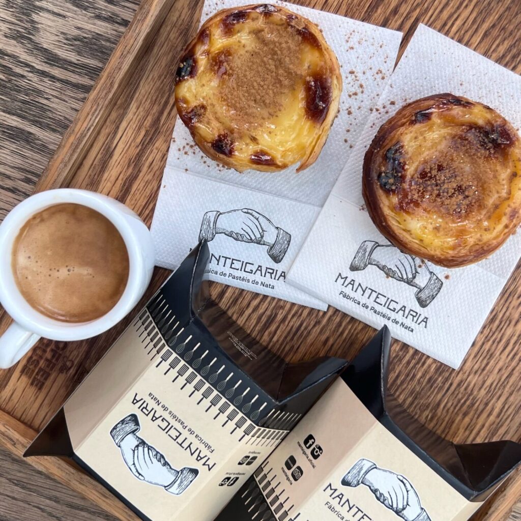 Close-up of a freshly baked pastel de nata, a traditional Portuguese custard tart with a crispy, flaky crust and creamy filling